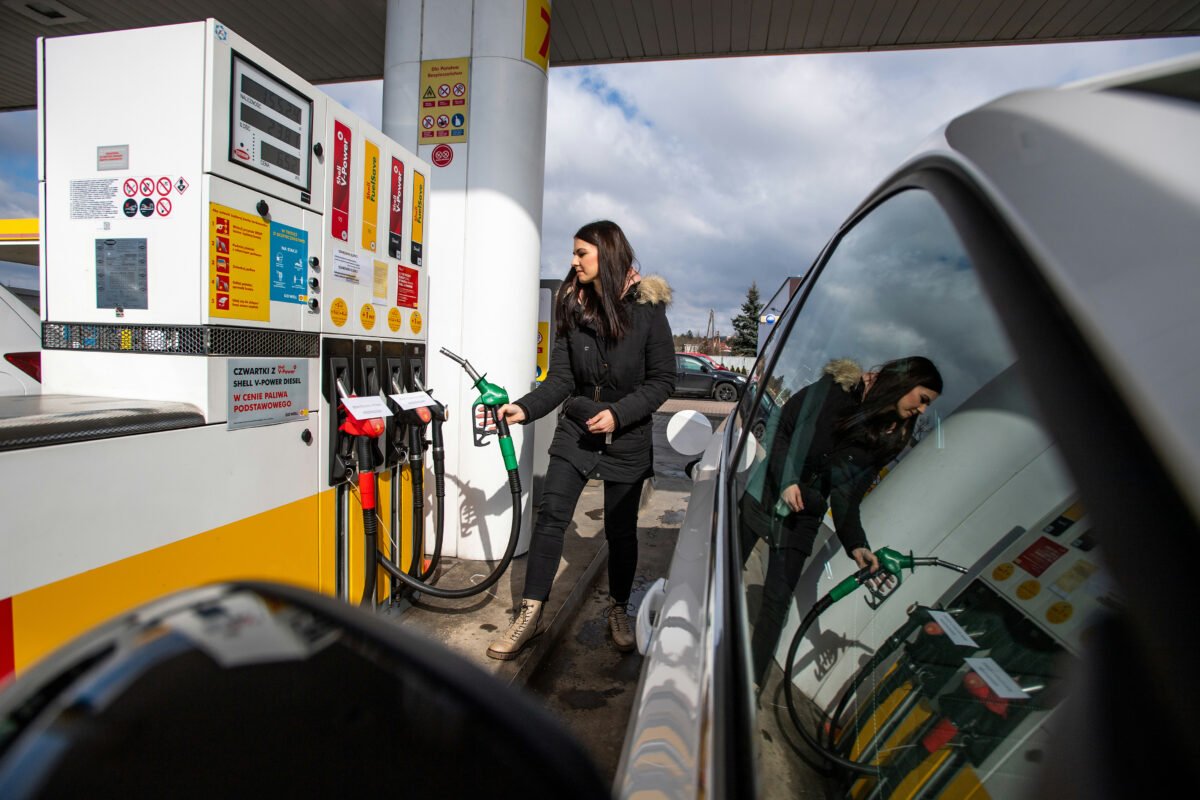 Archivo - Una checa reposta combustible en una gasolinera (archivo). Gasolina.